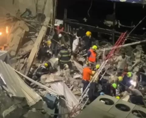 Desplome del techo del Jet Set deja muertos, heridos y atrapados Santo Domingo.– Una tragedia sacudió la madrugada de este lunes a la capital dominicana, luego de que se desplomara el techo de la emblemática discoteca Jet Set, ubicada en la avenida Independencia, a la altura del kilómetro 6, en el Distrito Nacional. El colapso de la estructura ha dejado un saldo preliminar de muertos, heridos y varias personas atrapadas entre los escombros. Un amplio dispositivo de emergencia se mantiene activo en la zona, donde unidades de la Policía Nacional, las Fuerzas Armadas, el Cuerpo de Bomberos del Distrito Nacional y la Defensa Civil trabajan de manera coordinada para rescatar a las personas que permanecen atrapadas en el interior del establecimiento. El general Juan Manuel Méndez, director del Centro de Operaciones de Emergencias (COE), confirmó que se han desplegado todos los recursos disponibles para atender la situación, incluyendo maquinaria pesada, ambulancias y equipos especializados de rescate. “Estamos haciendo todo lo posible para salvar vidas. Hay un trabajo intenso de los organismos de socorro, y no descansaremos hasta sacar a todos los que estén debajo de los escombros”, declaró Méndez a medios de comunicación en el lugar del hecho. Por su parte, el presidente Luis Abinader ha estado siguiendo la situación “minuto a minuto” y, según reveló el director del COE, ha ordenado movilizar todos los recursos del Estado para dar una respuesta rápida y eficaz a esta emergencia. Aún no se ha precisado la causa del colapso ni se ha divulgado una cifra oficial de víctimas. Las autoridades indicaron que ofrecerán detalles a medida que avance el operativo de rescate. La discoteca Jet Set, conocida por ser un ícono del entretenimiento nocturno en Santo Domingo y escenario de presentaciones de artistas nacionales e internacionales, estaba operando con normalidad cuando ocurrió el derrumbe.
